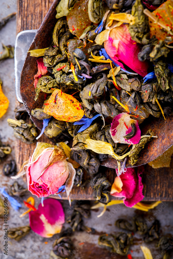 Dry Tea on the basis of Green with fruits and  rose petals, cornflower and calendula on a wooden background