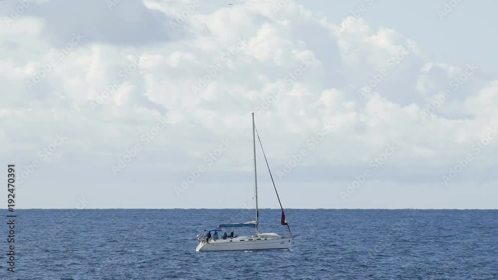 Boat with furled sails sailing across blue sea under cloudy sky, recreation Boat with furled sails sailing across blue sea under cloudy sky, recreation