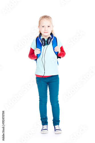 Portrait of little girl with earphones walking to school