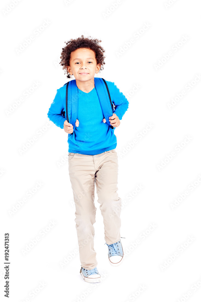 Portrait of cute curly-haired Latin American boy with backpack walking to school Portrait of cute curly-haired Latin American boy with backpack walking to school