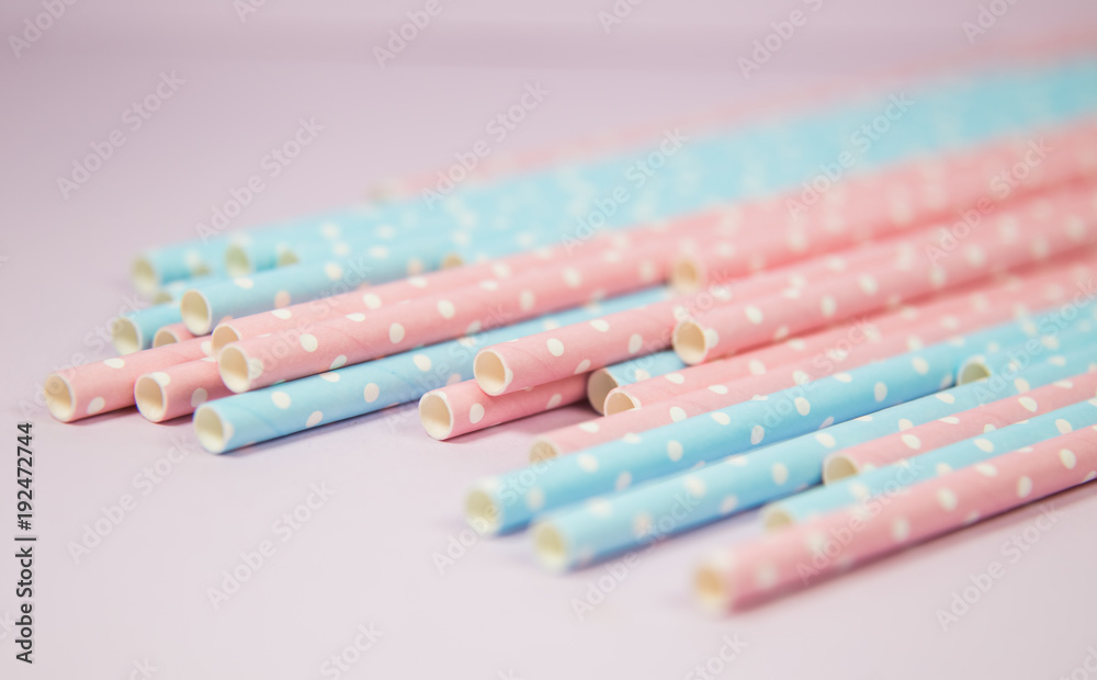 Blue and pink polka dot straws in the pink background