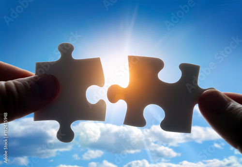 Konstfotografi Putting puzzle pieces together on sky background with sunlight