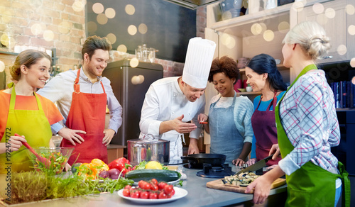 happy friends and chef cook cooking in kitchen photo