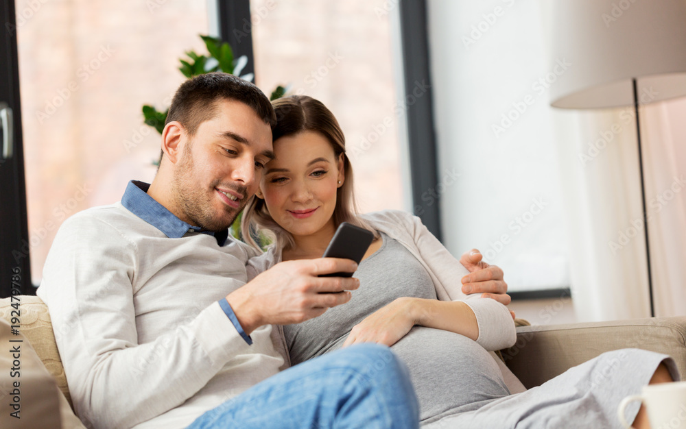man and pregnant wife with smartphone at home man and pregnant wife with smartphone at home