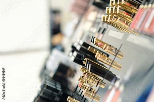 A woman takes a lipstick, in a cosmetics store