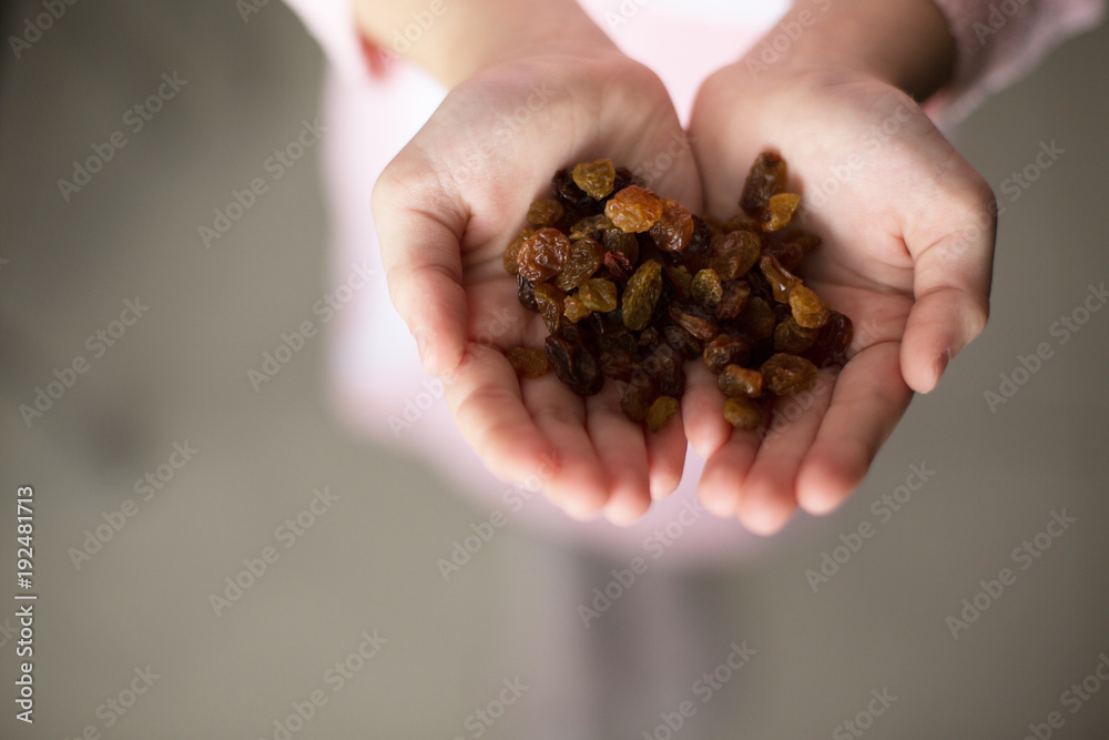 little girl holding raisins in her hands. little girl holding raisins in her hands.