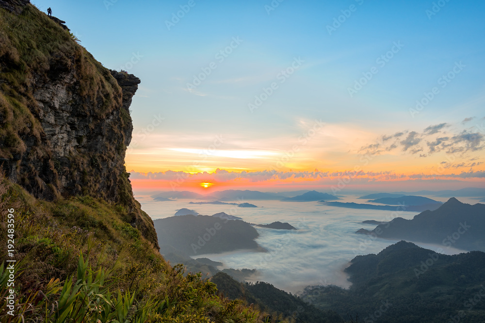 Obraz premium Mountain view with morning fog and Sunrise scene with the peak of mountain at Phu chi fa in Chiangrai,Thailand