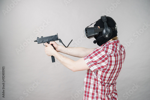 Gamer man wearing VR holding gun