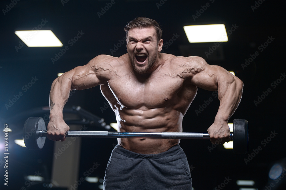Brutal strong bodybuilder athletic men pumping up muscles with dumbbells. Brutal strong bodybuilder athletic men pumping up muscles with dumbbells.