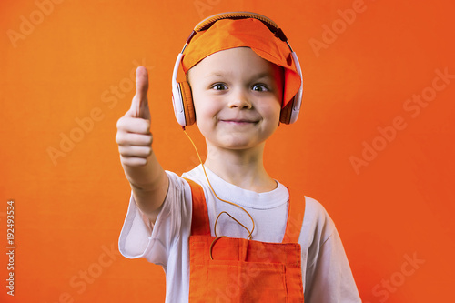 funny boy builder with headphones doing repairs on bright background