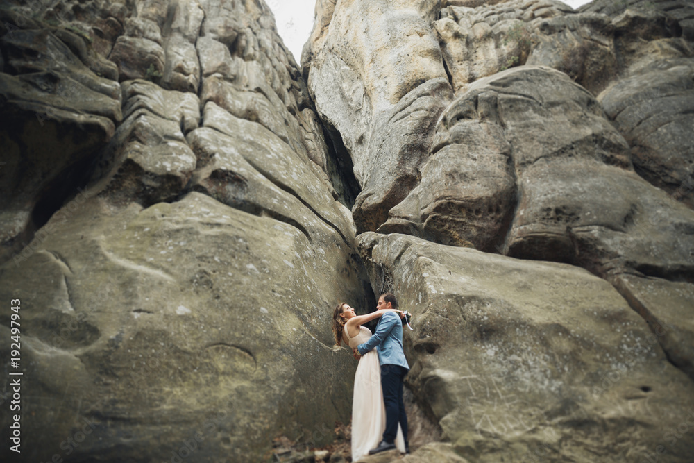 Happy wedding couple kissing and hugging near a high cliff Happy wedding couple kissing and hugging near a high cliff