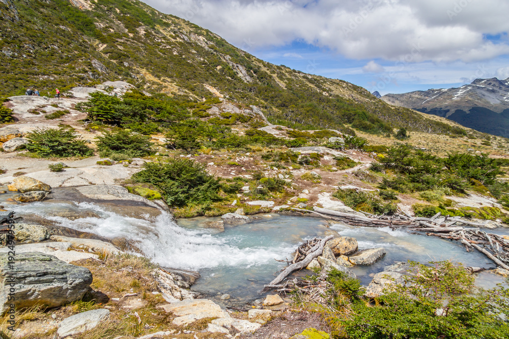Waterfall in Laguna Esmeralda trail with mountains and vegetation Waterfall in Laguna Esmeralda trail with mountains and vegetation