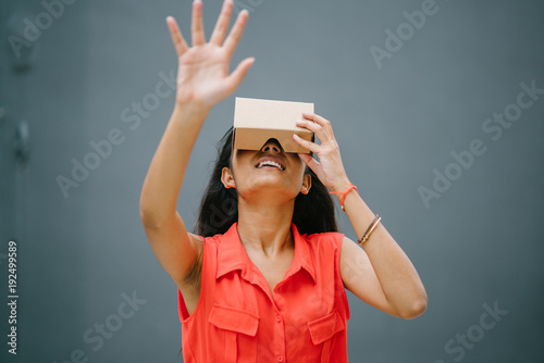 For the first time, a young and photogenic Indian woman tries glasses of virtual reality. She smiles and laughs at the experience with pleasure and surprise. photo