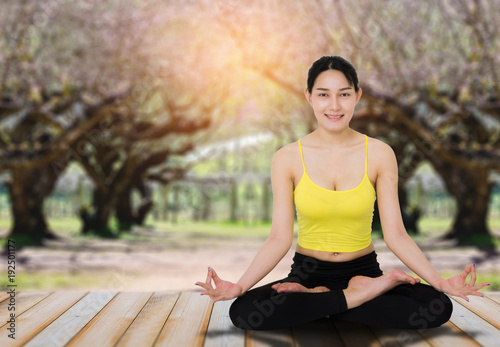 beautiful asian woman practice yoga pose with natural tree in park blur bokeh background. © thithawat