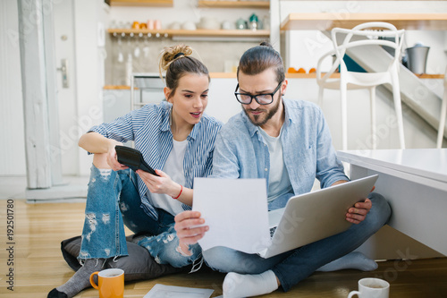 Young couple calculating their bills at home photo