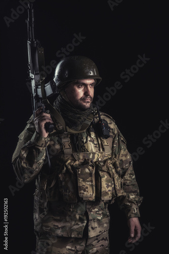 The volunteer on black background with guns and a walkie-talkie