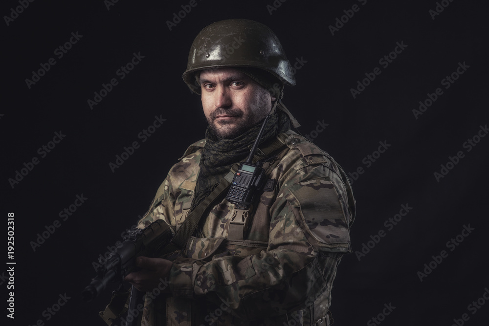 The volunteer on black background with guns and a walkie-talkie The volunteer on black background with guns and a walkie-talkie