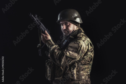 The volunteer on black background with guns and a walkie-talkie