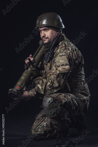 The volunteer on black background with guns and a walkie-talkie