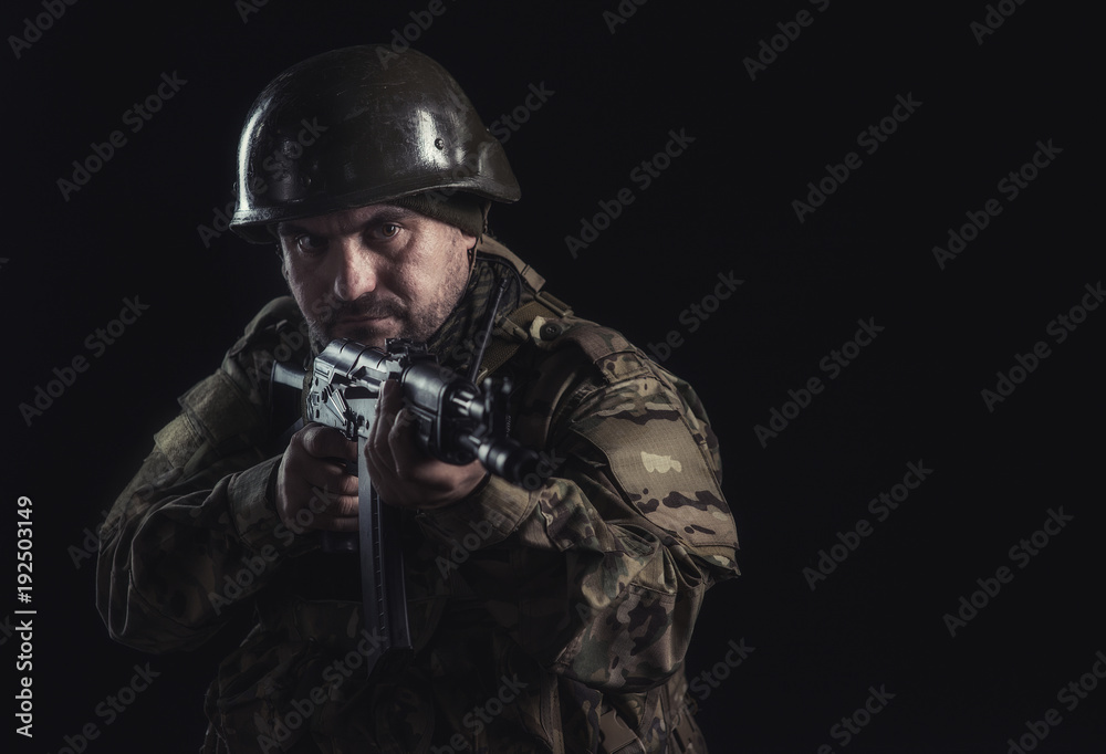 The volunteer on black background with guns and a walkie-talkie The volunteer on black background with guns and a walkie-talkie