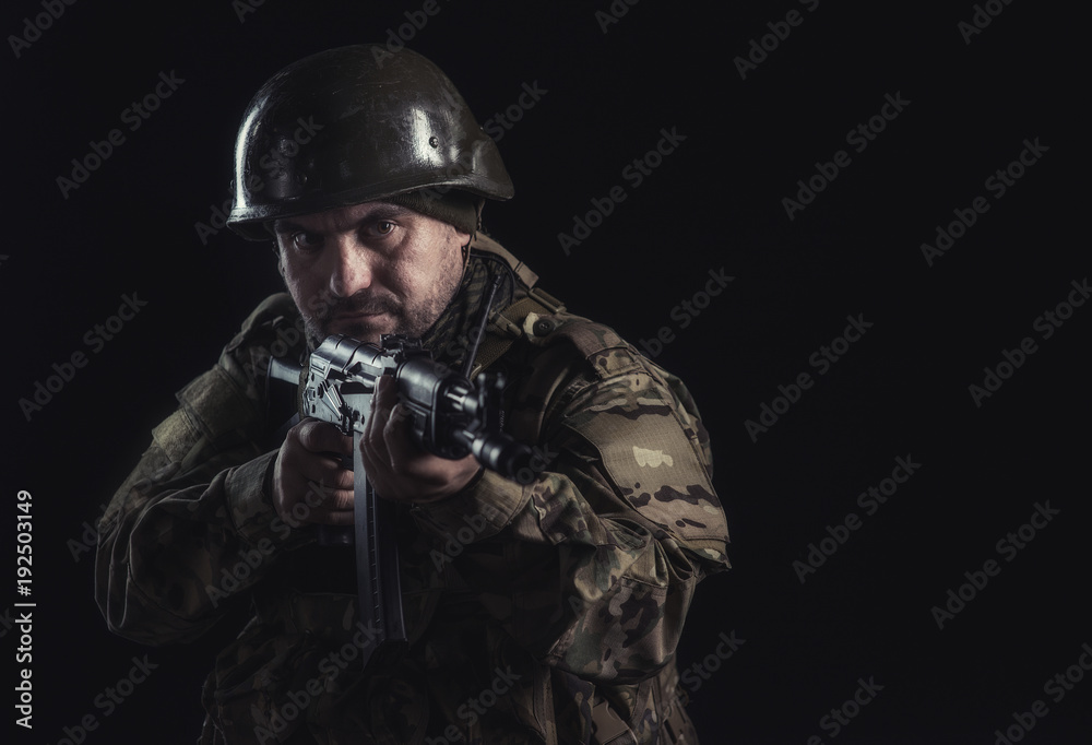 The volunteer on black background with guns and a walkie-talkie