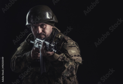 The volunteer on black background with guns and a walkie-talkie