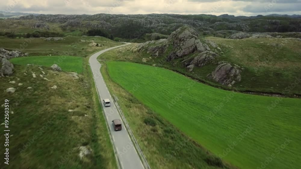 Aerial view on on the cars which are moving by breathtaking mountain road in Norway. Top view, green background full in trees and grass. 4k footage. Aerial view on on the cars which are moving by breathtaking mountain road in Norway. Top view, green background full in trees and grass. 4k footage.
