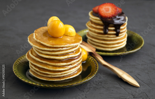 Pancakes with honey, chocolate and berries on a gray background. photo