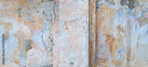grunge textured backgroundold. old house wall with cracked multicolor plaster.