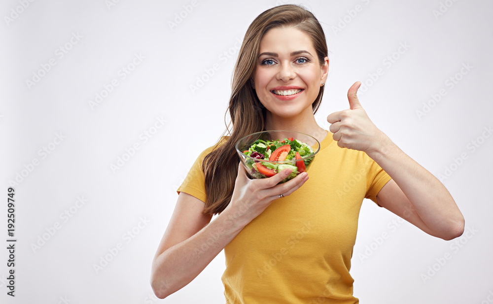 Smiling girl holding bowl with healthy green food salad and showing thumb up. Isolated white back. Smiling girl holding bowl with healthy green food salad and showing thumb up. Isolated white back.