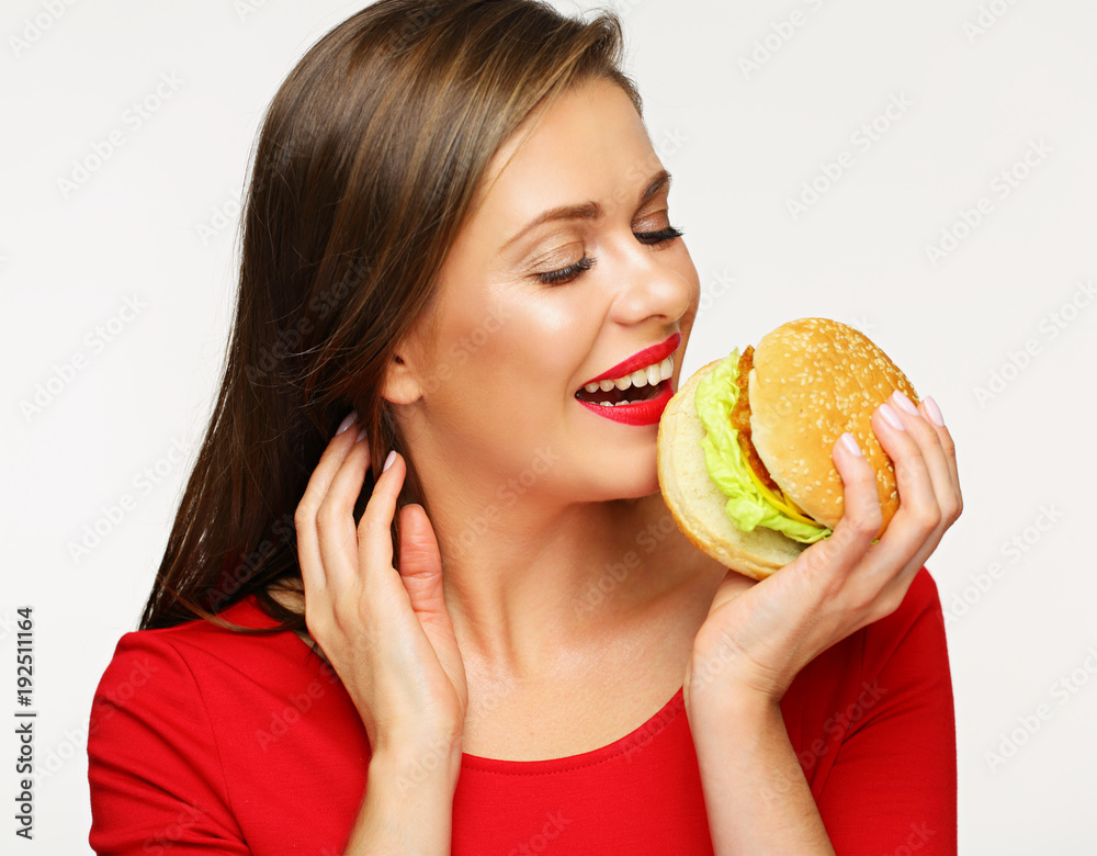 Smiling woman wearing red dress eating fast food burger. Smiling woman wearing red dress eating fast food burger.