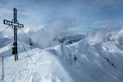 Gipfelkreuz mit Grad im Hintergrund im Winter