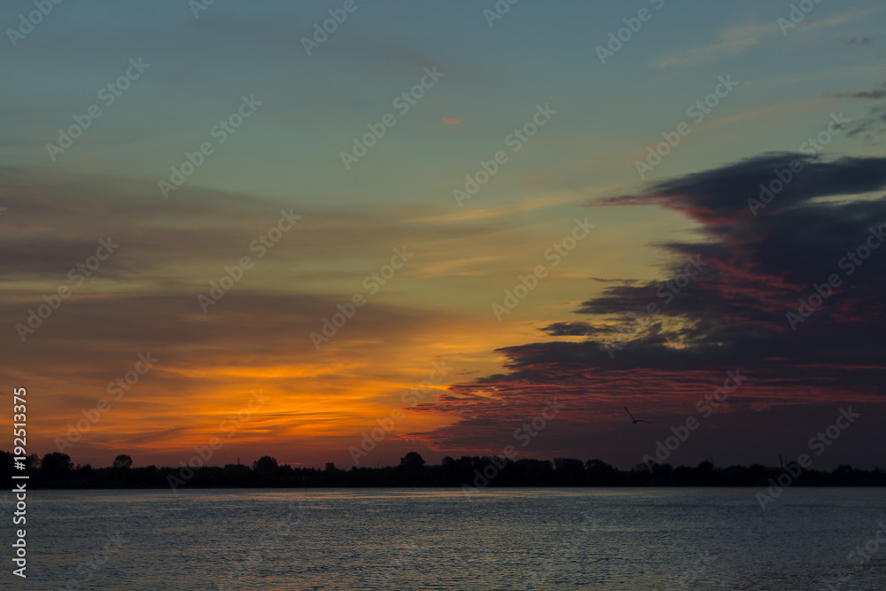 Beautiful sky against a background of sunset over the river