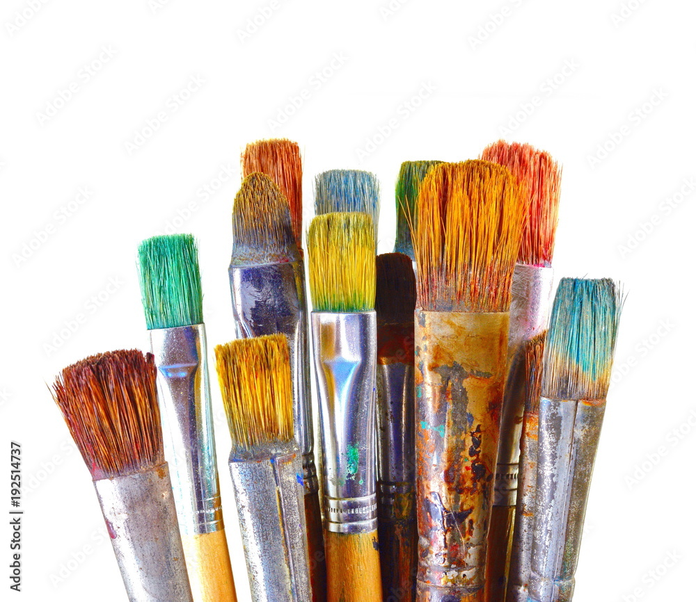 Various dirty paint brushes in a black cup isolated on white