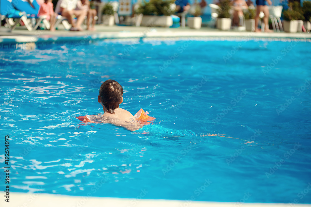 Caucasian boy swimming in the pool.