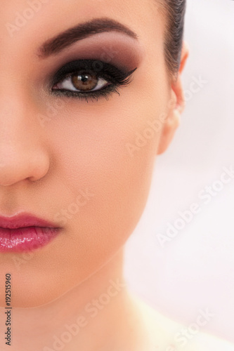 Beautiful young model with professional make up, close up shot on the white background