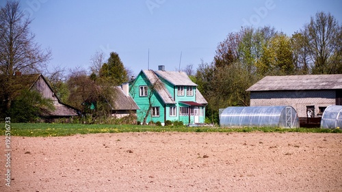 arable land with a turquoise chalet at the background in Lithuania © Adrian
