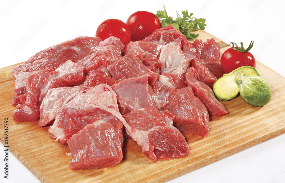 fresh raw red cubed meat chunk on wooden cut board isolated over white background
