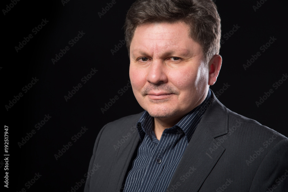 Portrait of a middle aged business man on a dark background. Close up face. Portrait of a middle aged business man on a dark background. Close up face.