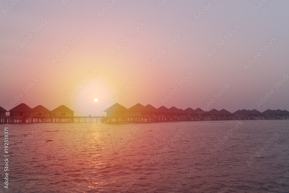 Naklejka premium Sunset at Maldives beach, luxury water lodges