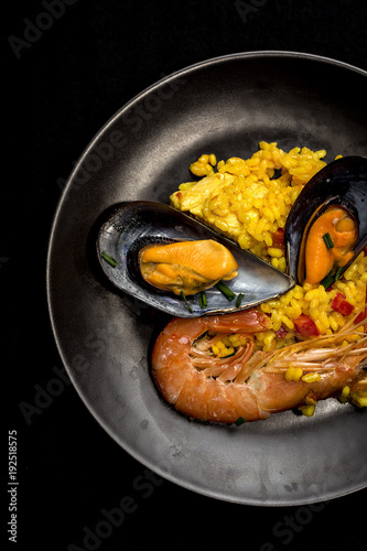 Traditional rice in paella with fish and meat.