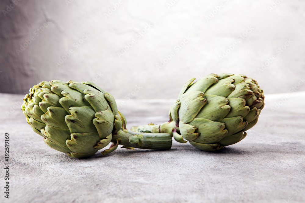 Fototapeta premium artichokes on grey background. fresh organic artichoke flower.