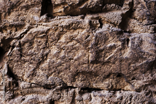 Close up Textured background of a wall of medieval stone masonry. The wall is sloppy built of mountain stones. Medieval style