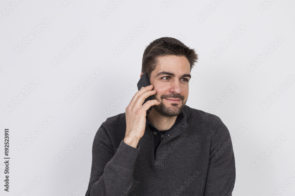 young man talking on his mobile phone. white background. technology and lifestyle young man talking on his mobile phone. white background. technology and lifestyle