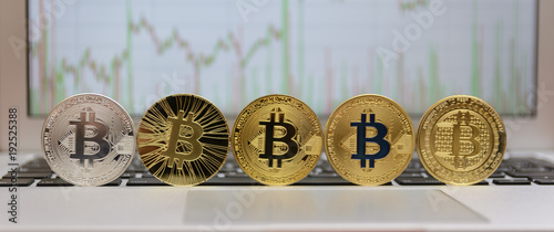  golden bitcoin on keyboard with chart on monitor