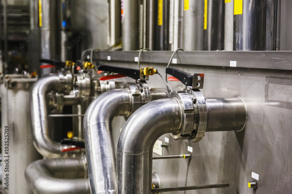 Steel pipes at modern beer factory, brewery concept. Steel tanks for beer production. Industrial background Steel pipes at modern beer factory, brewery concept. Steel tanks for beer production. Industrial background