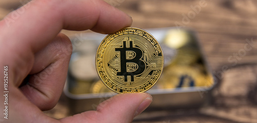  bitcoin holding in man’s fingers