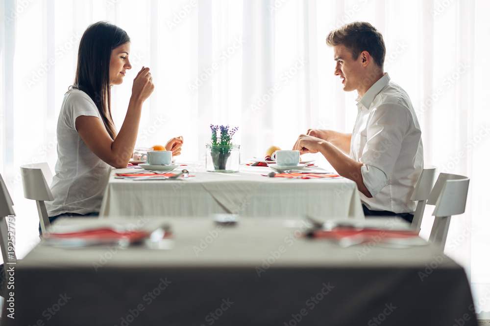 Two casual young adults having a conversation over a meal.Formal proposal,talking in a restaurant.Trying food,offers,special menu.Happy couple eating course in hotel.Meeting,date,special occasion