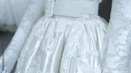 Wedding dresses in bridal boutique. Beautiful wedding dress. Close-up textile of wedding dress in boutique. Many white dresses in luxury Bridal salon.