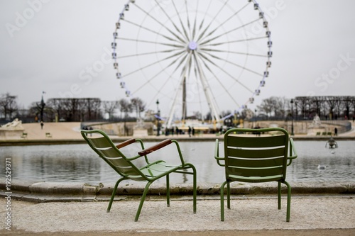 Zwei Stühle an einem Brunnen vor Pariser Riesenrad